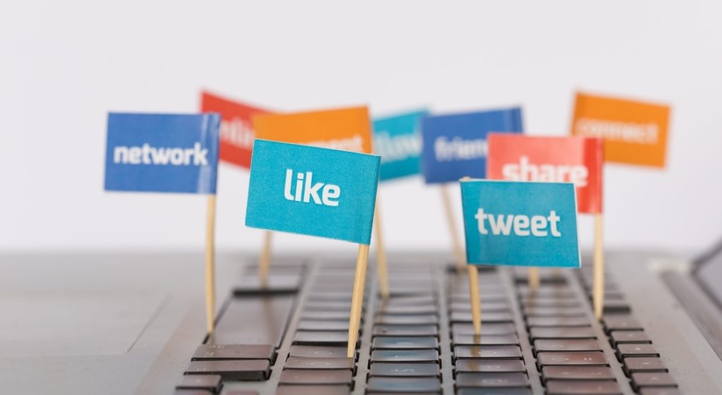The image shows a keybord with flags and words like "network", "tweet", "like"