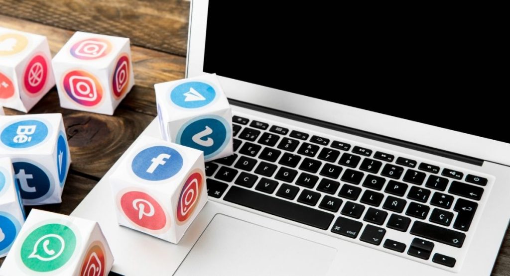 Why 2026 is the year to finally fix your digital presence. The image shows a laptop and some cubes with social media logos on them (freepik.com)